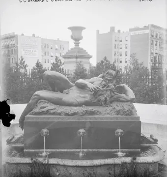 The Great God Pan bronze statue reclining and playing a pipe beside a fountain basin.