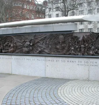 Battle of Britain Monument bronze relief panel with aircraft, pilots, and a Churchill quote on the stone base