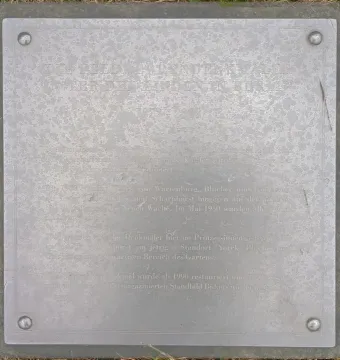 Weathered metal plaque on the Bülow Monument set into a dark stone base.