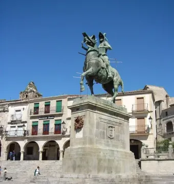 Francisco Pizarro equestrian statue on a stone pedestal in a sunlit square.