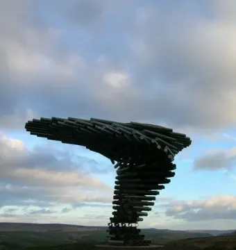 The Singing Ringing Tree sculpture on a grassy hill above a wide green valley.