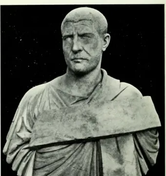 Bust of Philip the Arab with a closely cropped head, wrinkled forehead, and draped garment on a small pedestal.