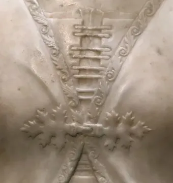 Detail of the Bust of a Young Woman showing carved foliage bands and oak leaf motifs in white marble.