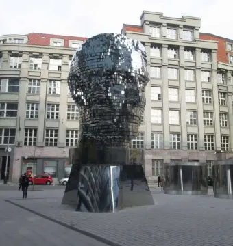The Head of Franz Kafka sculpture in Prague, a towering reflective head made of horizontal mirrored panels.