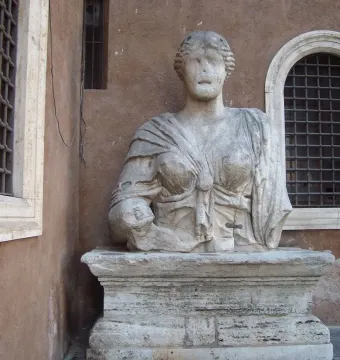 Madama Lucrezia, a weathered stone statue of a draped woman with an eroded face on a pedestal.