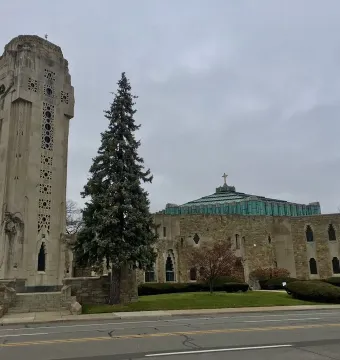 National Shrine of the Little Flower with its stone crucifixion tower beside the sanctuary and green domed roof.