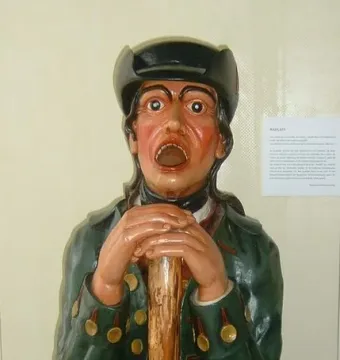 Aschaffenburger Maulaff sculpture of a man in a tricorne hat and green coat with mouth open.