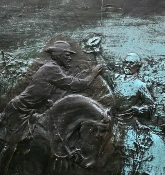 Bronze relief panel from the John Brown Gordon statue showing a mounted figure reaching toward a standing man raising his hat.