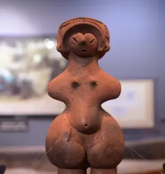 Jōmon Venus clay figurine with a patterned headdress, broad hips, and a rounded belly