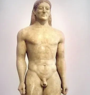 The Kroisos Kouros, a nude male marble statue standing with arms at its sides and braided hair.