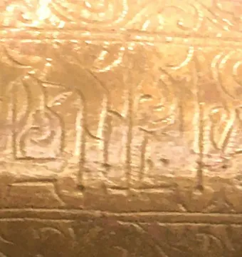 Close-up of the Lion of Monzon showing gilded calligraphic inscription and floral ornament