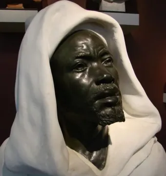 Salem, Negro of Sudan, a dark metal bust of a bearded man in a white hooded garment.