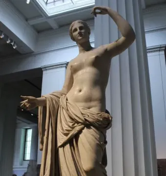 Townley Venus marble statue with one arm raised and draped fabric over the lower body.