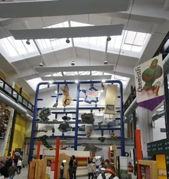 Entropa sculpture with a tall blue grid structure and suspended fragmented forms in an exhibition hall.