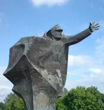 Kościuszkowców Memorial bronze statue of a uniformed figure with one arm outstretched on a stepped base