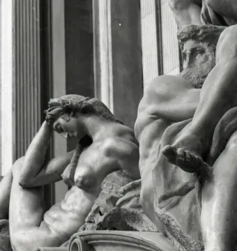 Detail of Michelangelo’s Night sculpture, showing a reclining female figure with her head resting on her hand beside a partial male figure and mask.