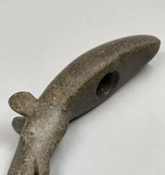 Alunda Moose carved stone sculpture with an animal head and elongated body, shown diagonally on a light gray background.