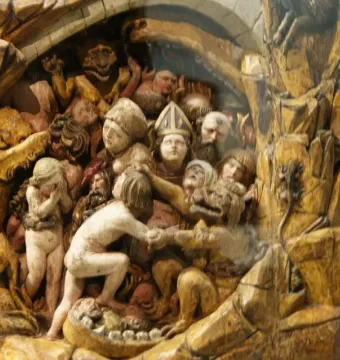Close-up of the Last Judgement sculpture showing a crowd of anguished figures among demons and rocky carvings.