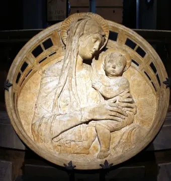 Madonna del Perdono relief showing the Madonna holding the child on her lap within a circular frame.