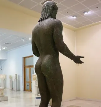Piraeus Apollo bronze statue seen from the rear right in a museum hall