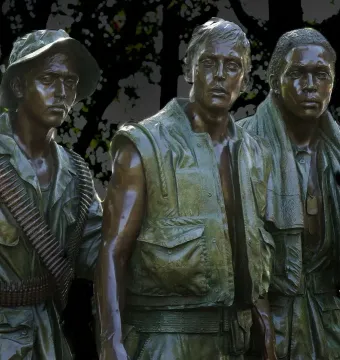The Three Soldiers bronze sculpture showing three solemn young men in military attire.