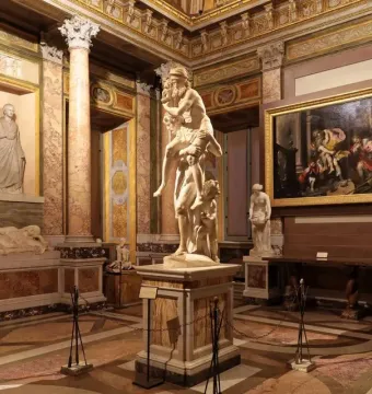 Aeneas, Anchises and Ascanius in white marble, showing a man carrying an older man with a child clinging to his leg.