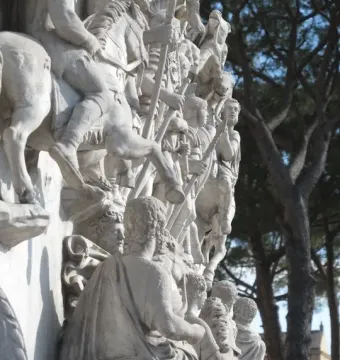 Carved white stone relief from the Antoninus Pius Column showing figures in classical dress, some on horseback and others standing with staffs.