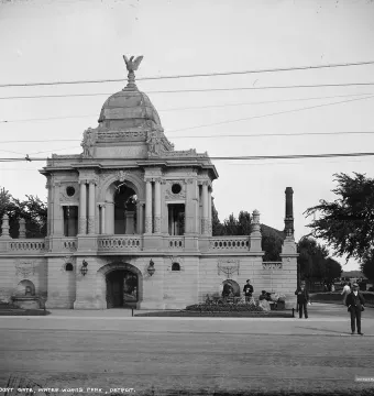 Hurlbut Memorial Gate, an ornate stone entrance with columns, arches, and a domed roof topped by an eagle, with people nearby.