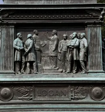 Bronze base of the Major General John A. Logan monument with a relief of several men and a plaque reading Logan.