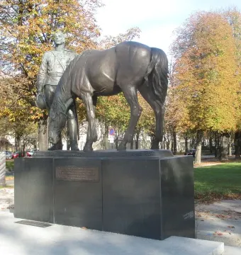Monument to the Russian Expeditionary Force showing a bronze military officer beside a horse on a granite pedestal.