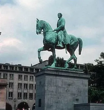 Albert I equestrian statue on a stone pedestal in a public square, with buildings and steps in the background.