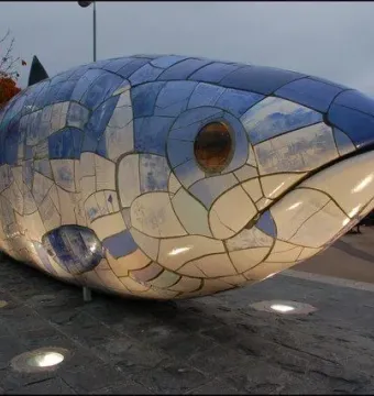 The Big Fish sculpture in Belfast lit by ground-level lights at night.