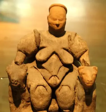 Seated Woman of Çatalhöyük sculpture showing a large woman seated on a throne with two feline heads beside her hands.