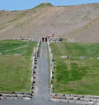 Stone rows lead along a gravel path toward the Omphalos on a hillside at Crawick Multiverse.