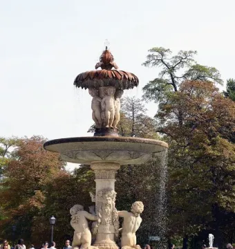 Fountain of the Artichoke with carved figures supporting a fluted basin and water cascading down its tiers.