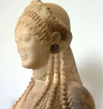 Korè 675 shown from the side, with braided hair, a headband, and circular earrings.