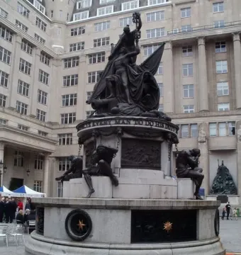 Nelson Monument with bronze figures around its stone base and a sculptural group at the top.