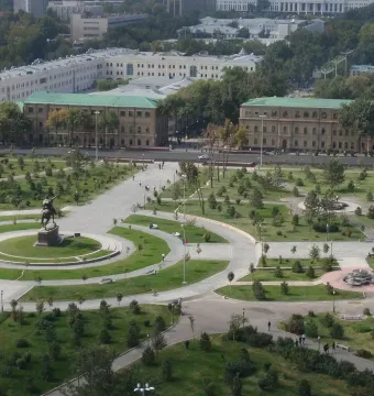 Timur equestrian statue on a pedestal in a landscaped park with lawns, trees, and paths.