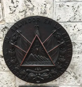 Bronze El Salvador plaque mounted on the curved stone wall of The Torch of Friendship.