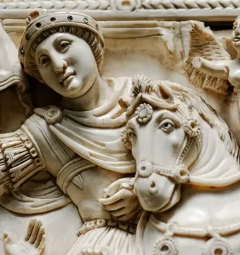 Barberini Ivory carving showing a crowned horseman with a staff and a small winged figure beside him.