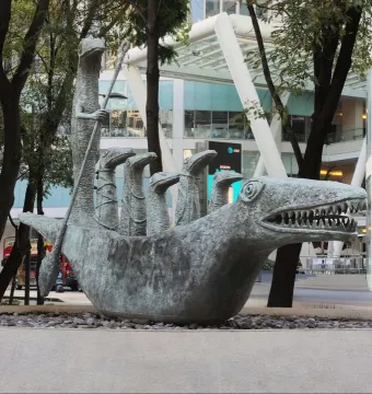 How Doth the Little Crocodile sculpture with a metallic reptile head and smaller figures inside.