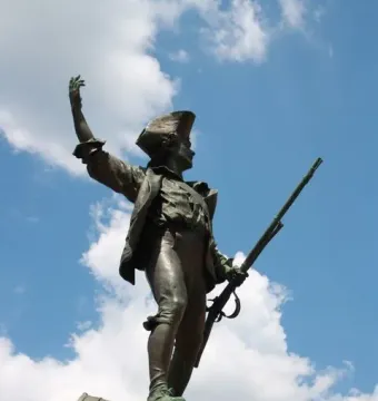 Statue of the Volunteer of 1792, a bronze soldier holding a rifle and raising one arm on a stone pedestal.