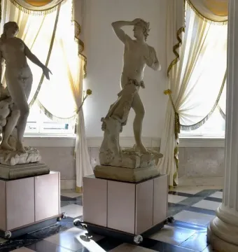 Orfeo y Eurídice by Canova, two white marble statues on pink pedestals in a museum room