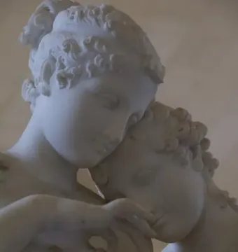 Close-up of Standing Psyche and Love in white marble, showing the upper bodies and faces of two figures leaning toward each other.