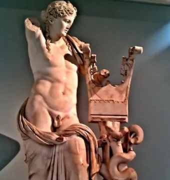 Apollo of Cyrene marble statue leaning on a carved column with a coiled snake, missing its right arm