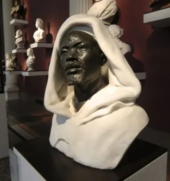 Salem, Negro of Sudan bust displayed on a pedestal in a museum hall with other portrait busts in the background.