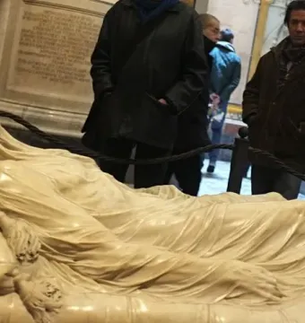 The Veiled Christ marble sculpture of a recumbent figure covered by a transparent-looking veil, with visitors in the background.