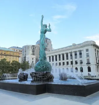 The Fountain of Eternal Life bronze sculpture rises from a large basin with water jets spraying around it.