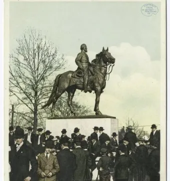Nathan Bedford Forrest Monument shown as an equestrian statue on a stone pedestal, with a crowd gathered around it in a park.