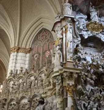The Transparente in Toledo Cathedral, with an ornate Baroque altarpiece of marble figures, cherubs, and gilded carvings.